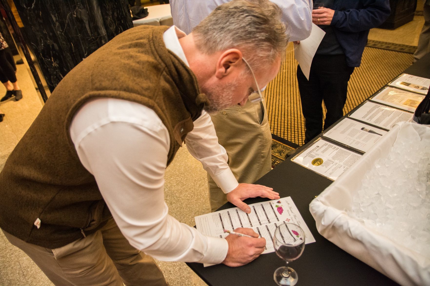Bob Fritz marks off wine he has tasted on his wine tasting menu